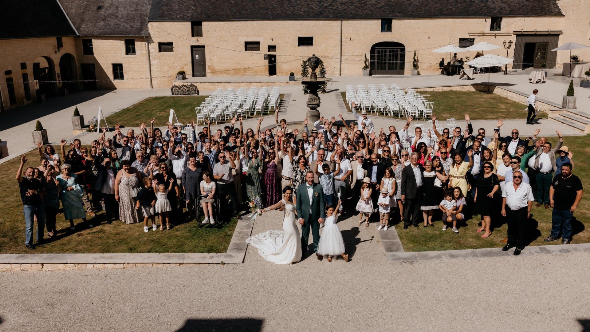 Mariés entourés de tous leurs invités dans la Cour d'Honneur du Domaine de la Cour des Lys lors d'un mariage en Calvados, entre Caen et Bayeux