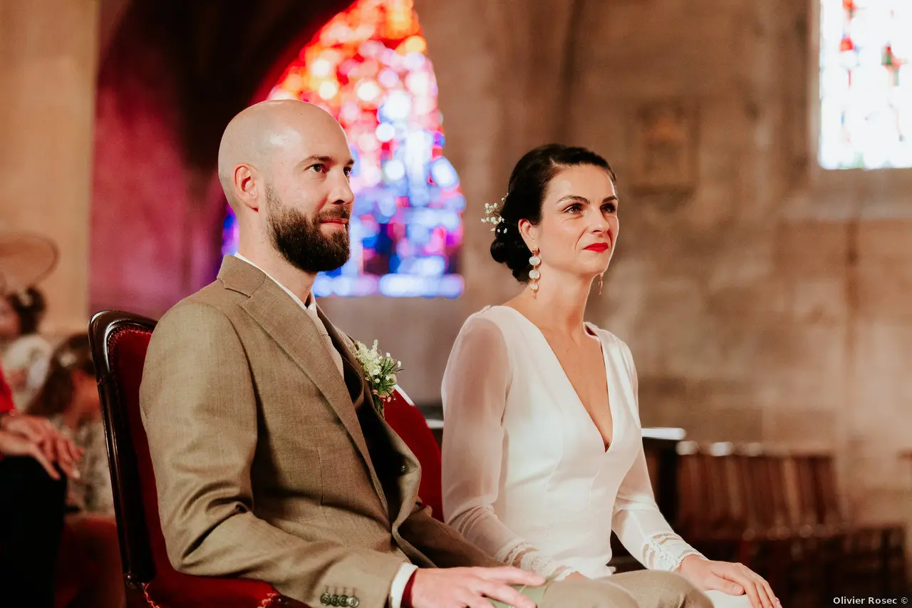 Mariage automne Domaine de la Cour des Lys en Normandie — Adélaïde et Charles lors de leur cérémonie religieuse à Caen, vitraux en arrière-plan, 8 novembre 2025