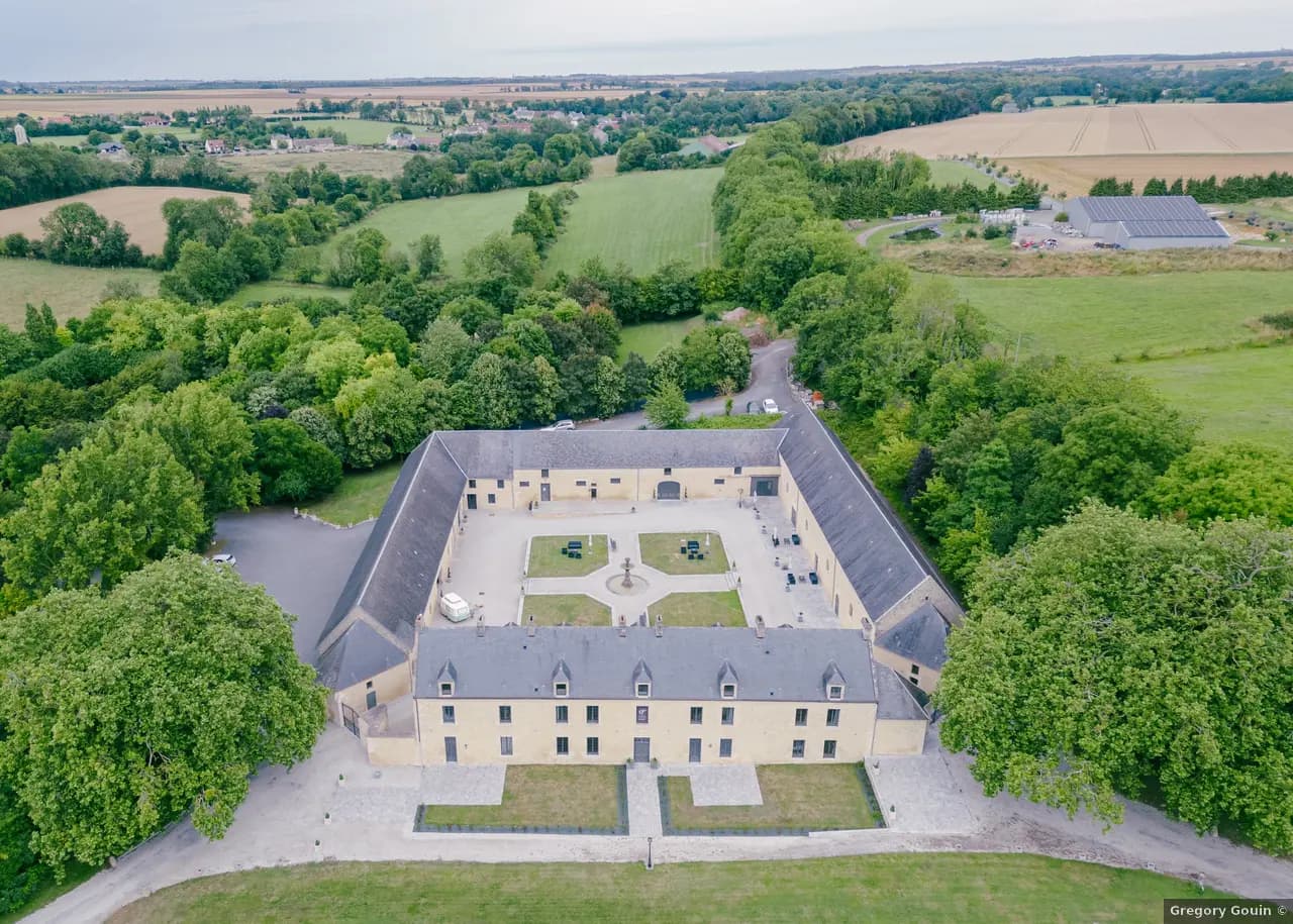 Vue aérienne Domaine de la Cour des Lys en été — bâtisses en Pierre de Caen, Cour d'Honneur, parc paysager de 2,5 hectares au cœur du Bessin Calvados