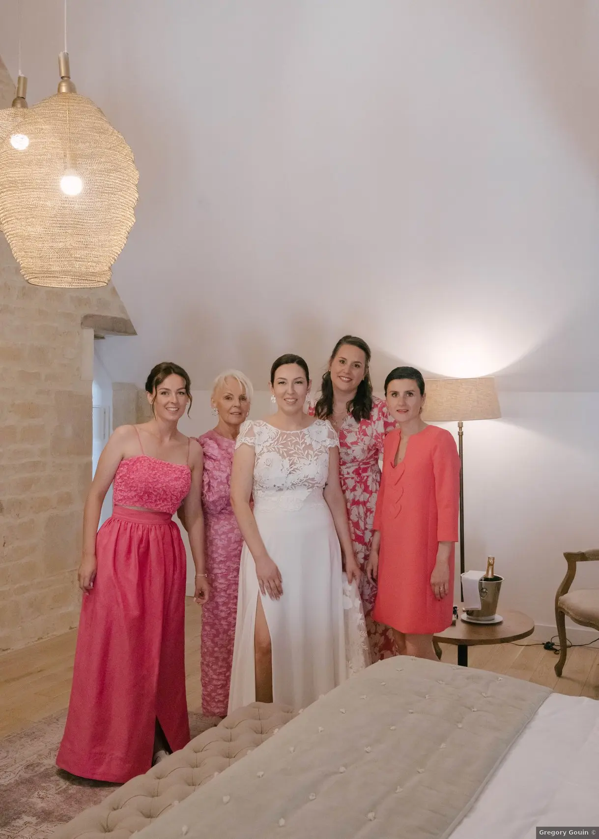 Mariée et famille Domaine de la Cour des Lys — Lise entourée de sa mère et de ses témoins dans la suite nuptiale avant la cérémonie, robes roses et corail