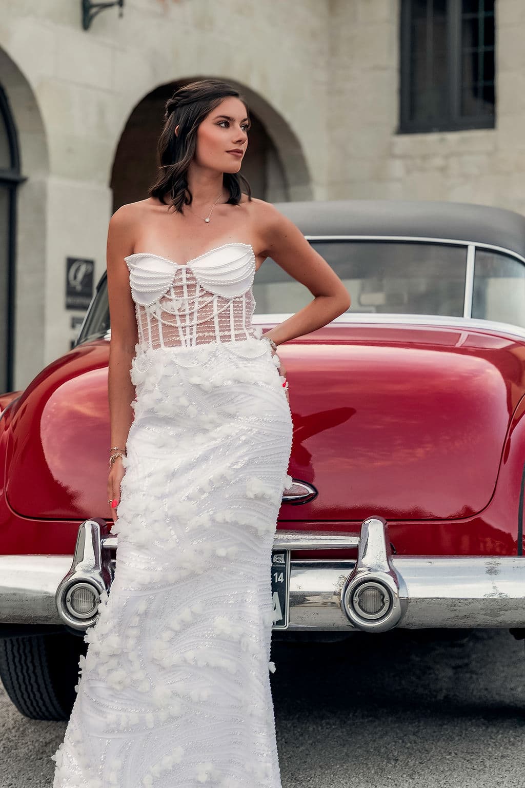 Robe blanche et voiture de collection dans la cour du Domaine